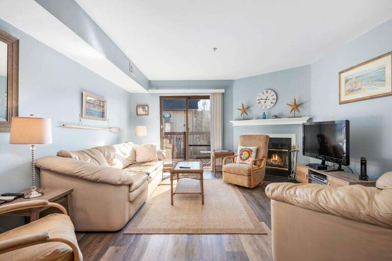 Blue-walled Living Space With Beige Sofas, Wooden Floors, And Seaside Decor