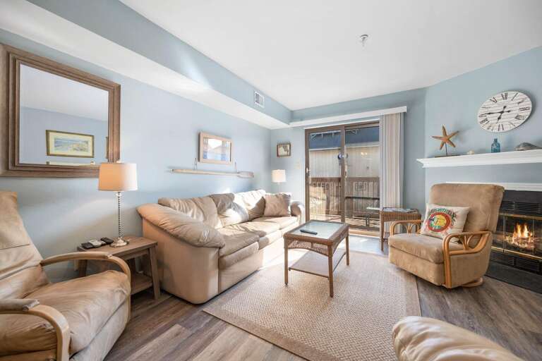 Serene Sitting Space, Soft Sofas, Subtle Shades, Stone Fireplace, Sliding Balcony Door