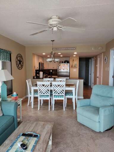 Spacious Living Space With A White Dining Table Set And Adjoining Kitchen Area