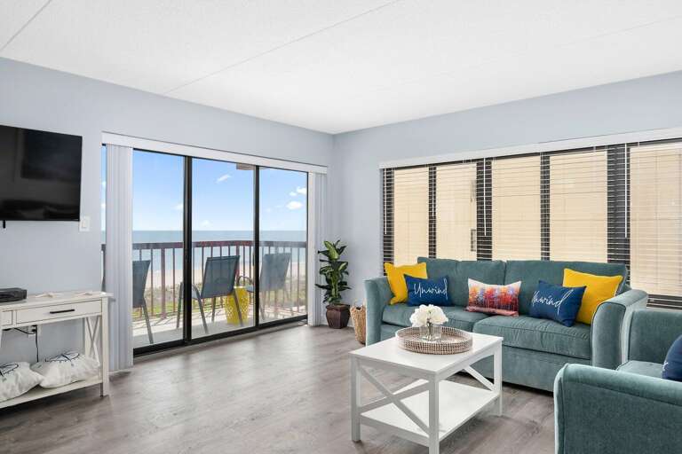 Sleek Sea-view Sitting Space With Sliding Doors, Sectional Sofa, And Subtle Shades