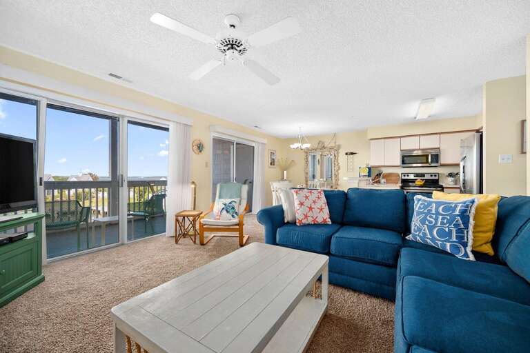 Bright Beachside Living Room Leading To Balcony In Vacation Rental