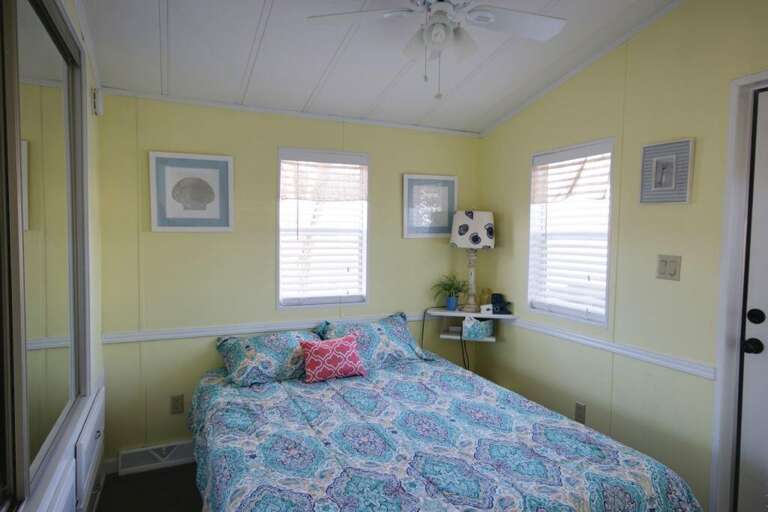 Yellow-walled Room With Teal Bedspread And Complemented By Light-luring Windows