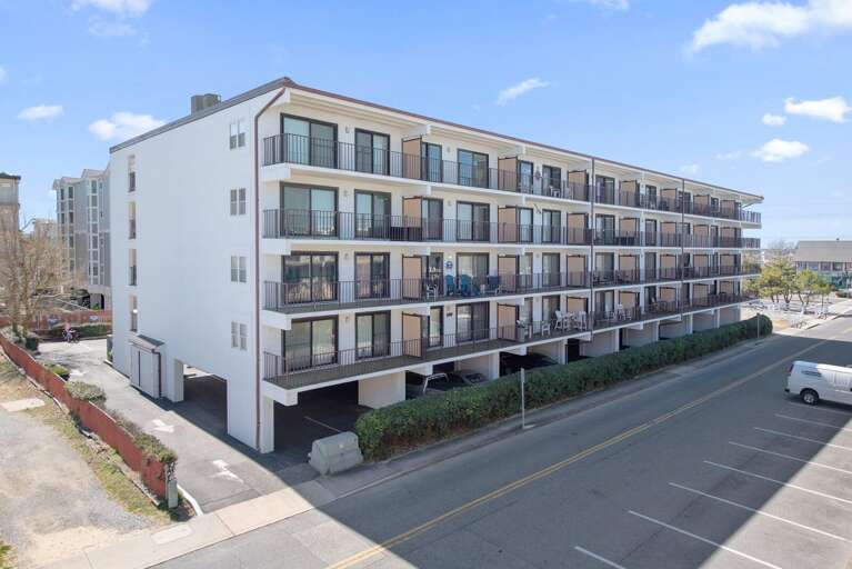 White Building With Balconies Beside Busy Street