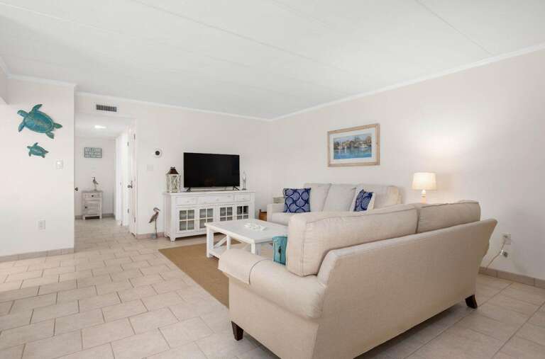 Plush Sofa In A Pristine Living Room With Pale Walls And Tile Floors