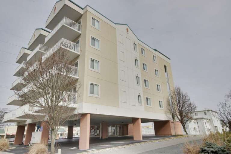 Vacation Rental Venue Under Vast Sky, Balcony Building By Barren Branches