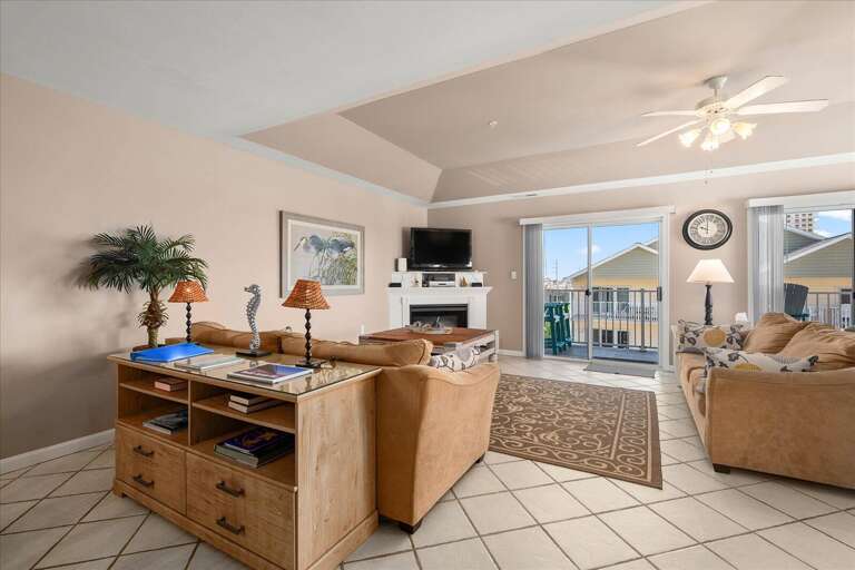 Brightly Lit Living Area Leading To A Sunny Balcony, Vacation Rental Space Equipped With Plush Seating And TV