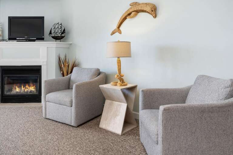 Living Space With Gray Sofas, Fireplace, And Mounted Driftwood Decor