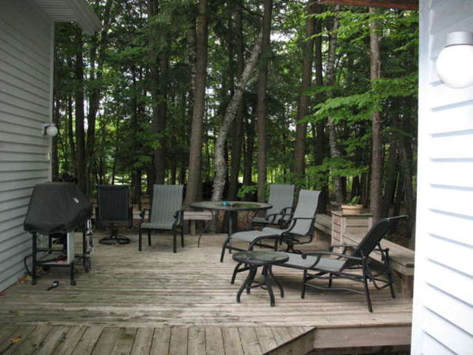 Wooden Deck With Outdoor Furniture And Barbecue Grill Surrounded By Trees Wooden Deck With Outdoor Furniture And Barbecue Grill Surrounded By Trees