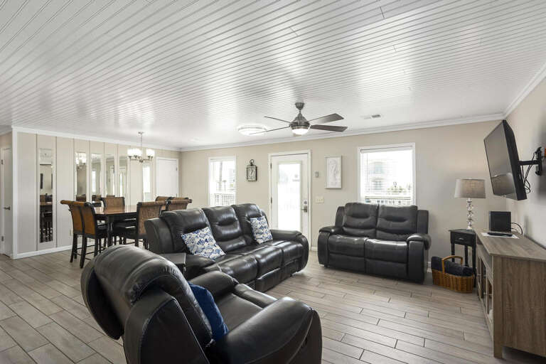 Interior Living Space With Leather Sofas, Dining Table, And Mounted Television