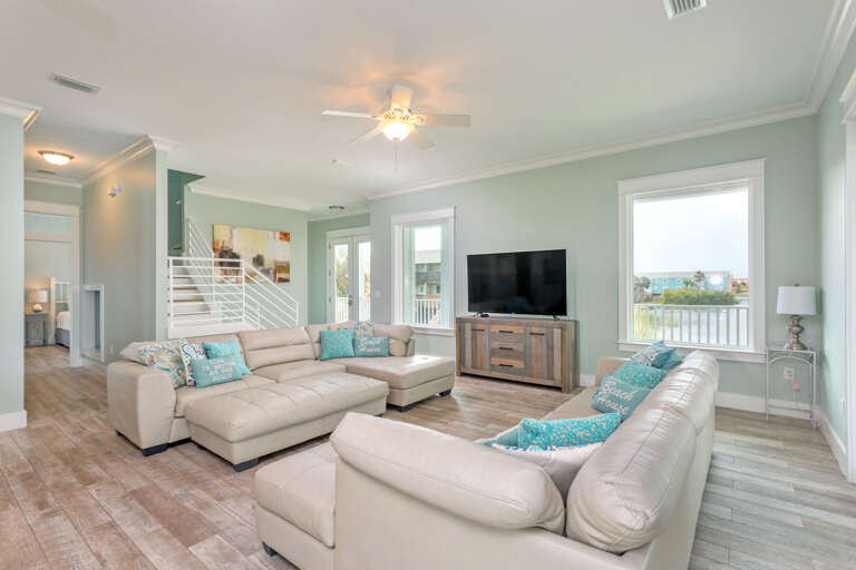 Living Room With Sofas, TV, And Staircase