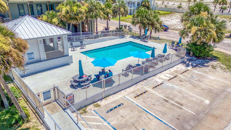 Aerial View Of A Beachside Vacation Rental With Swimming Pool And Parking Area