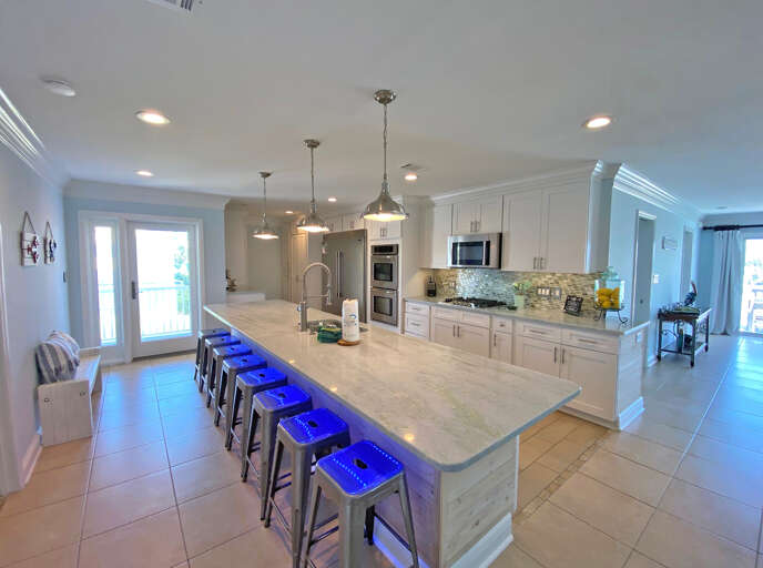 Spacious Kitchen Interior With Large Island And Blue Stools