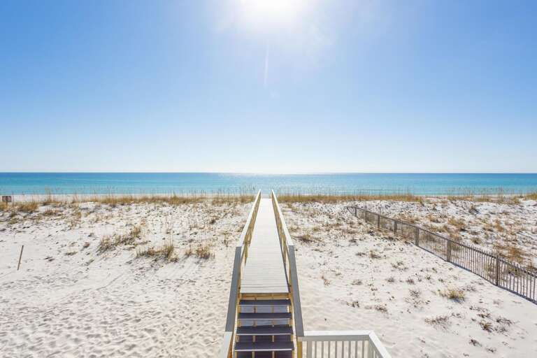 Boardwalk Bridging Bright Beach, Blue Sea Beyond