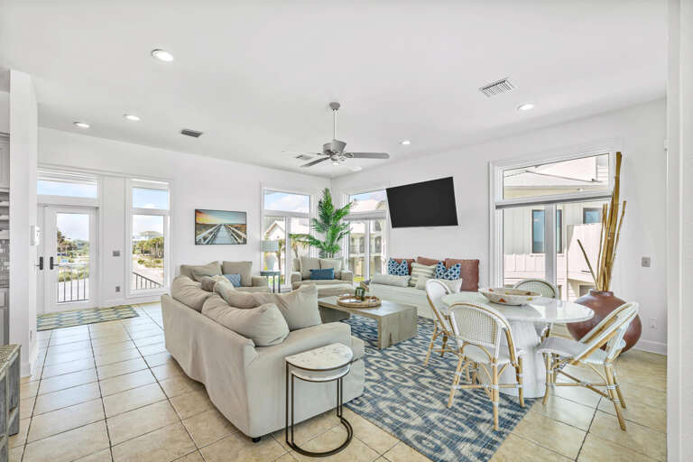 Bright, Breezy Living Space With Plush Sofas, Dining Area, And Sliding Doors To A Sunny Balcony
