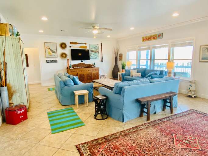Spacious Living Room With Blue Sofas And Dining Area, Bright Beach View