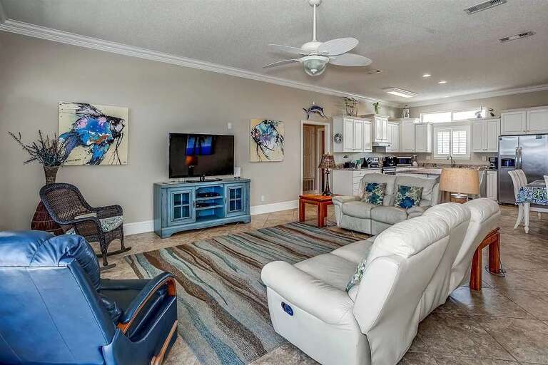 Spacious Living Space With Striped Sofa And Blue Cabinets, Ceiling Fan Above