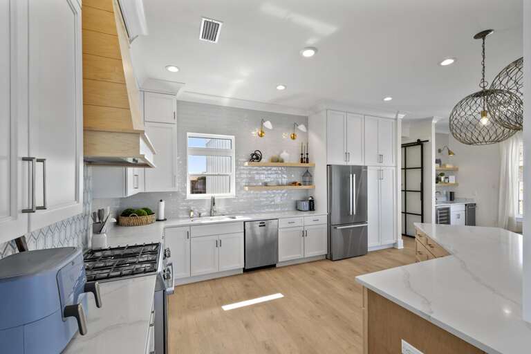 Bright Kitchen With White Cabinets And Stainless Steel Appliances