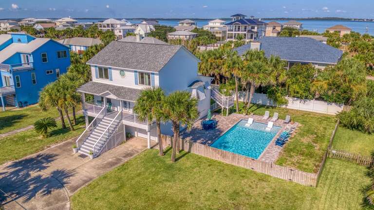 Aerial View Of A Coastal Building With Pool And Green Lawn