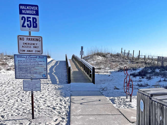 Beach Boardwalk Leading To Sandy Shore With Posted Signs