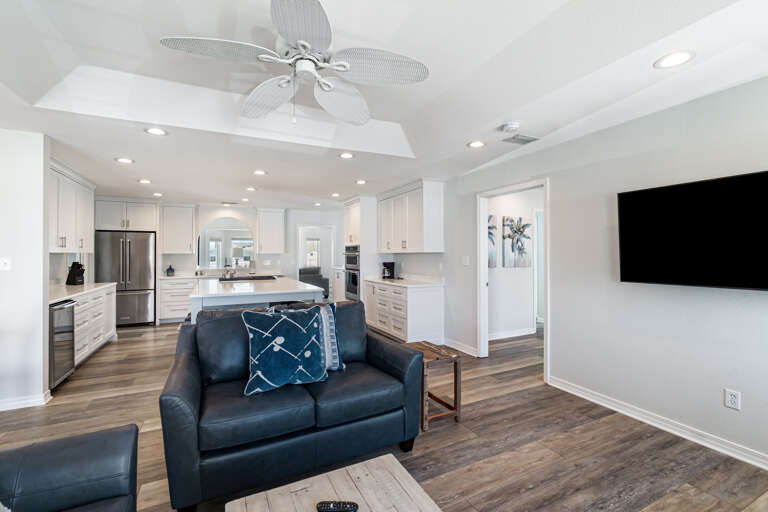 Living Space With Sofa, Kitchen, And Mounted Television