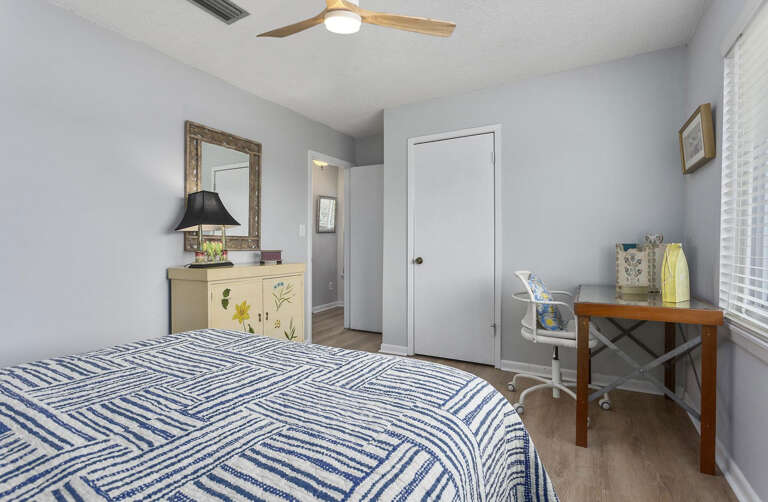 Interior Of A Bedroom With Striped Bedding And Ceiling Fan Interior Of A Bedroom With Striped Bedding And Ceiling Fan