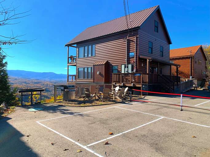 Brown Building Beneath Blue Sky, Mountain Backdrop