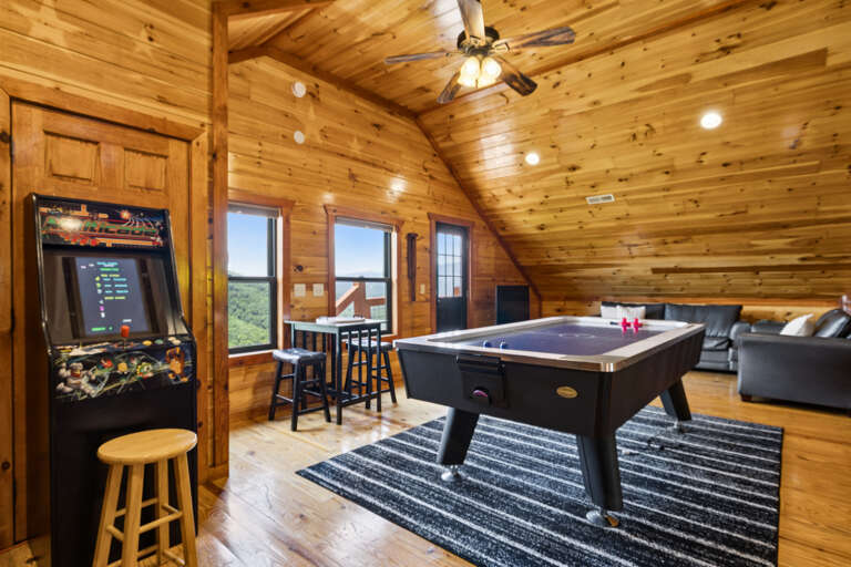 Wood-paneled Game Room With Pool Table, Arcade Machine, And Plush Seating Overlooking Scenic Views