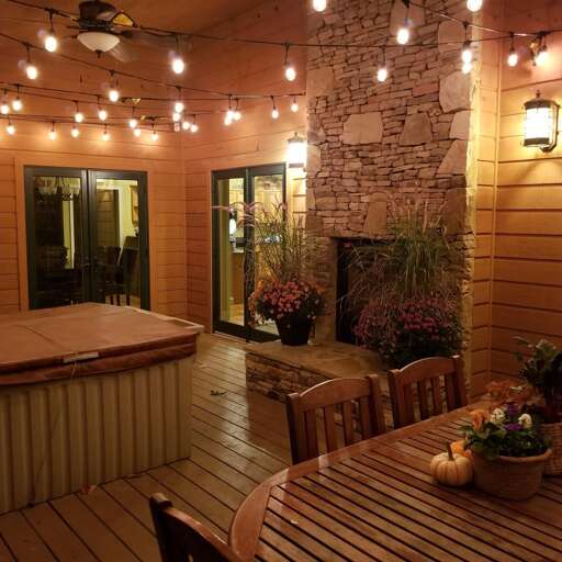 Patio With String Lights, Plants, And Wooden Furniture