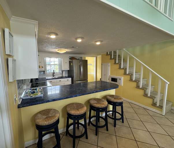 Kitchen showing bar/stairs to the loft