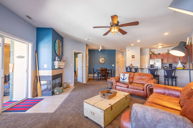 Blue-walled Living Space With Brown Leather Sofas And Sleek Ceiling Fan