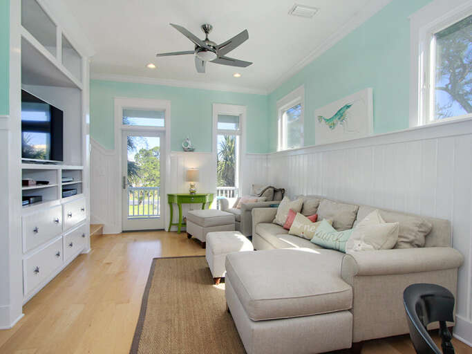 Light Living Space With Beige Sofa, Pastel Walls, And Breezy Balcony View