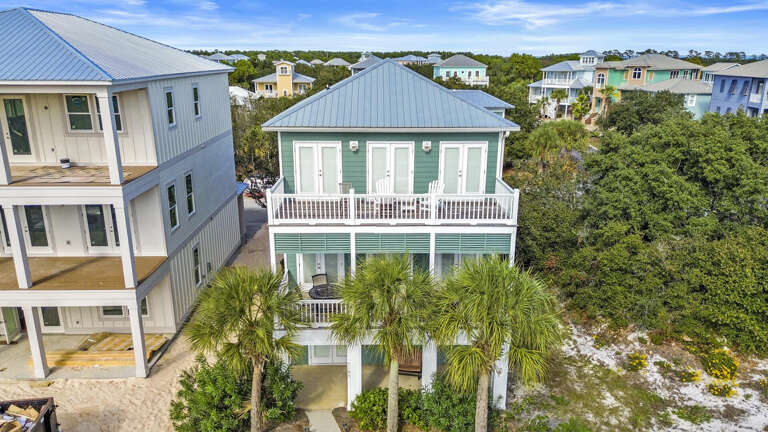 Blue Building Between White Structures, Balconies Overlooking Trees