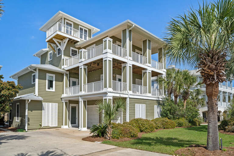 Vacation Rental: Towering Triple-tiered Structure With Sunlit Siding, Surrounded By Serene Greenery And A Solitary Palm