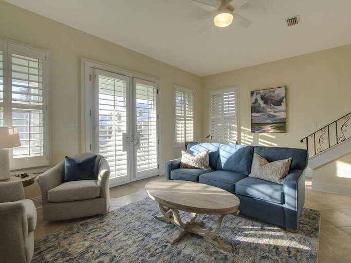 Bright Beachside Living Space With Blue Sofas And Ample Sunlight