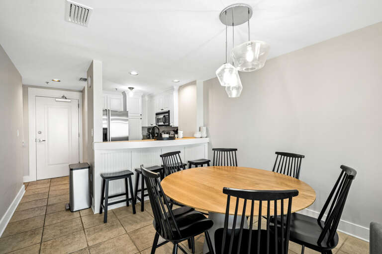 Round Table And Black Chairs In Spacious, Well-lit Kitchen-dining Area