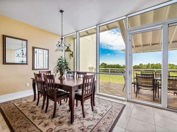 Dining Room With Wooden Table Set Near Sliding Glass Doors Overlooking Green Grass