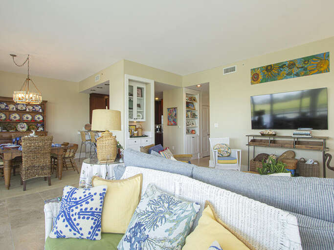 Living Room Leading Into Dining Area, With Plush Sofa And Vibrant Art
