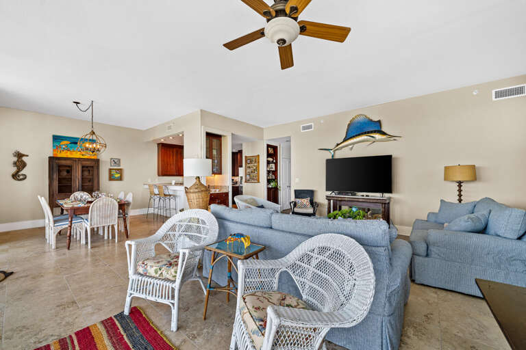 Spacious Living Space With White Wicker Chairs And Blue Sofas