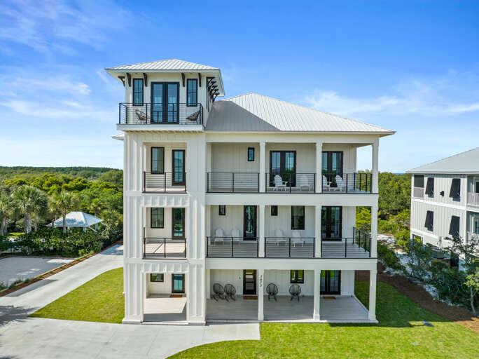 White-walled Residence With Rooftop Deck Surrounded By Green Grounds