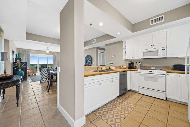 Interior View; Bright Kitchen Leading To Airy Living Space With Balcony
