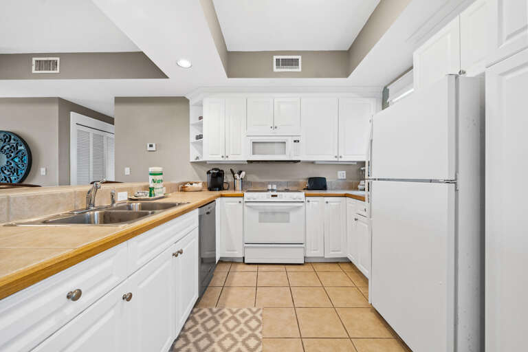 Spacious Kitchen With White Cabinets And Beige Countertops