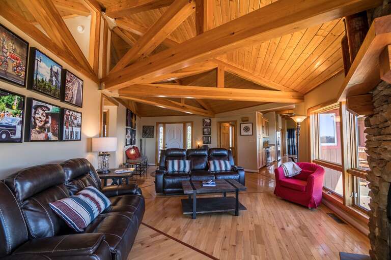 Cozy living room with reclining furniture around a stone gas log fireplace