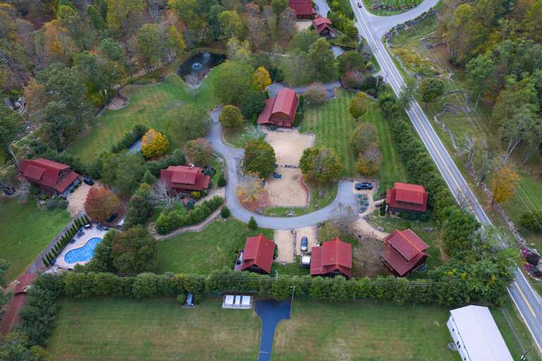 Aerial View Of Red-roofed Buildings Nestled Among Autumn-colored Trees