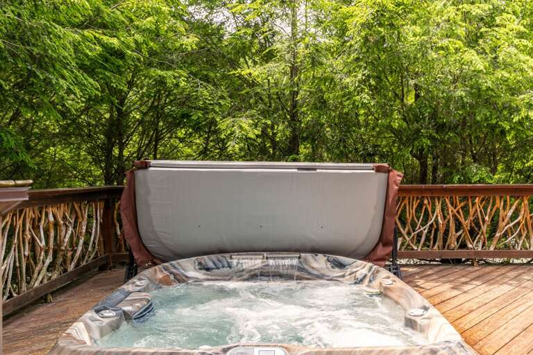 Outdoor Jacuzzi On Wooden Deck With Green Foliage Background