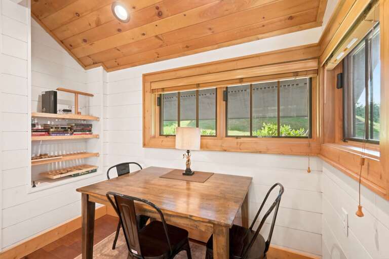 Cozy dining nook at Banner Sky, where warm wood ceilings and a bright yard view set the mood for a relaxed meal together.