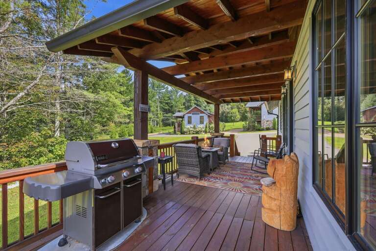 Fire up the grill and settle into a rocker on the covered deck at Banner Sky, with peaceful wooded views all around.