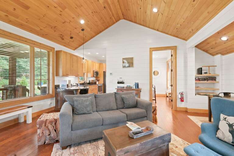 Vaulted knotty pine ceilings and rustic log accents give Banner Sky's open living space a cozy, mountain-retreat feel.