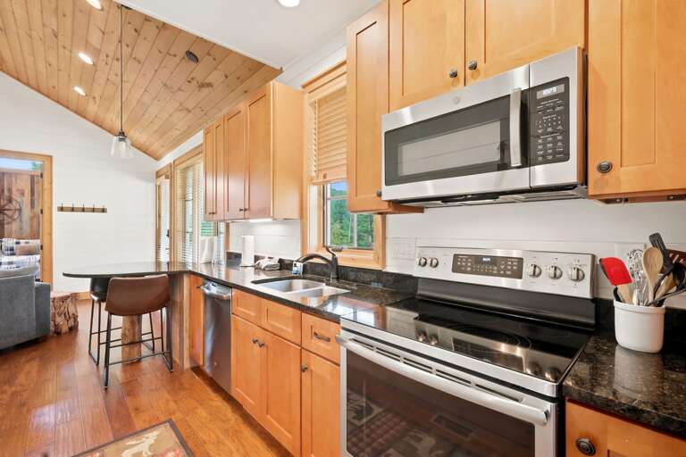 Warm wood cabinetry and dark granite counters make cooking feel cozy at Banner Sky. A dining nook sits just steps away.