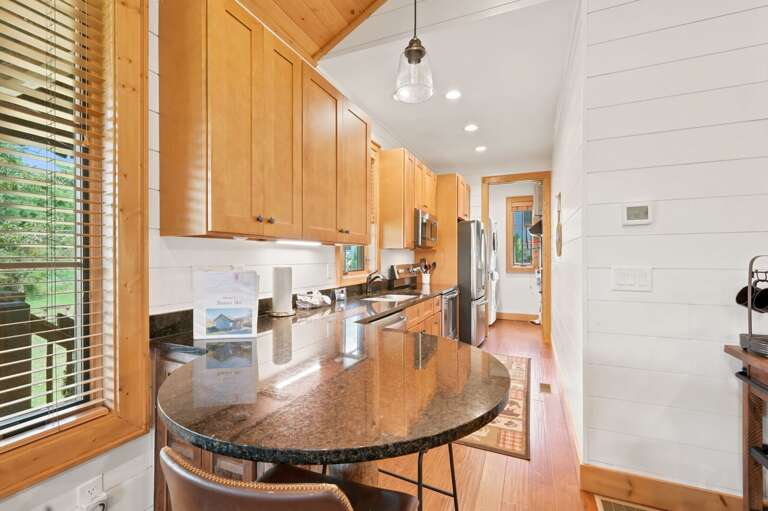 Warm wood cabinets and dark granite counters make cooking feel like part of the mountain experience at Banner Sky.