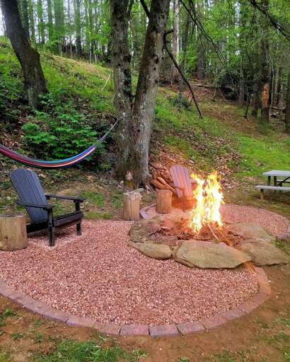 Outdoor Campfire With Seating And Hammock In Wooded Area